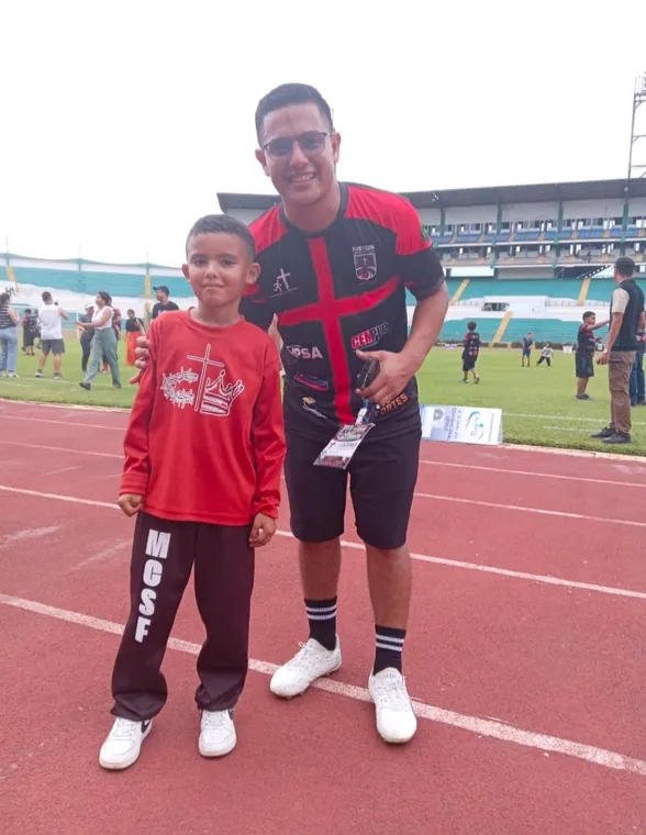 Niño y adulto con camisetas de la fundación en el estadio