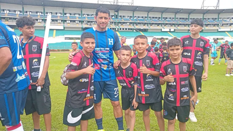 Grupo de niños de la fundación junto a un futbolista