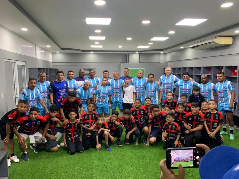 Niños y futbolistas reunidos para una fotografía de grupo