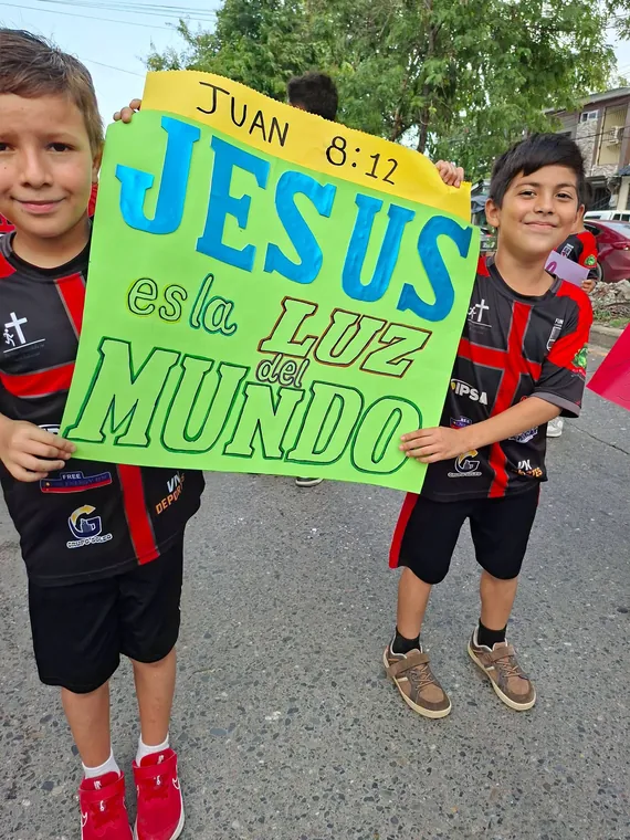 Niños con una pancarta que dice Jesús es la luz del mundo