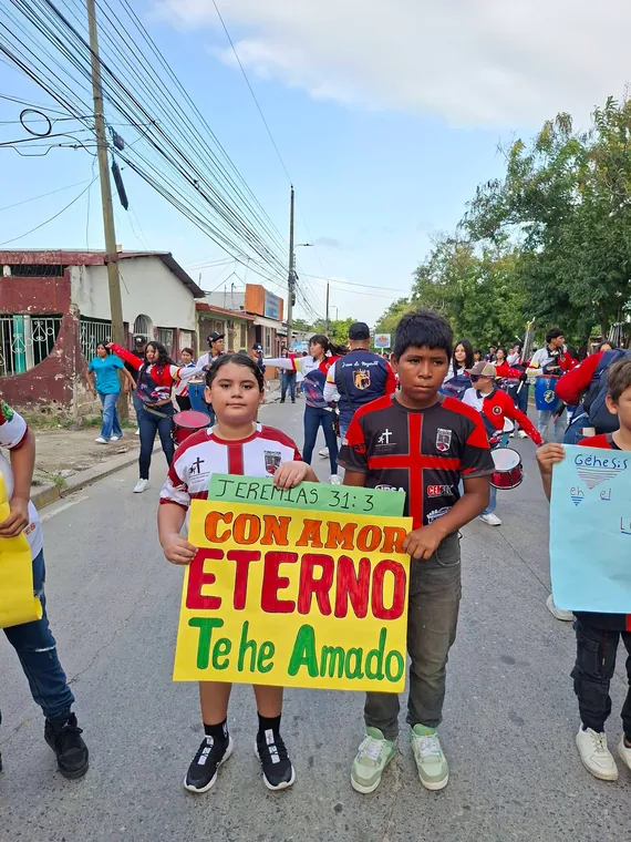 Niños sosteniendo una pancarta con un mensaje del libro de Jeremías